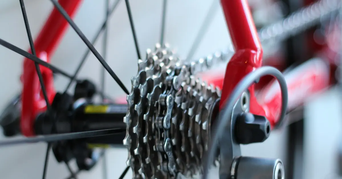 A rear cassette and chain on a red bike frame, close up.